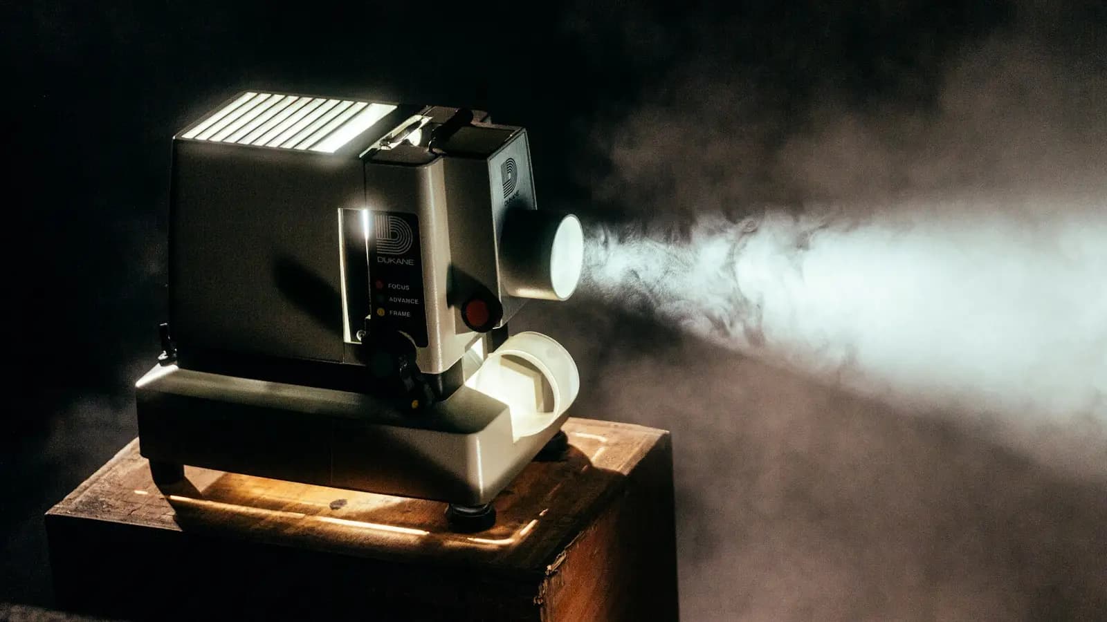 Film projector casting a light beam in a dark room